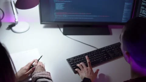Two colleagues programmers are sitting in front of a monitor and typing coding Stock Footage 157688729