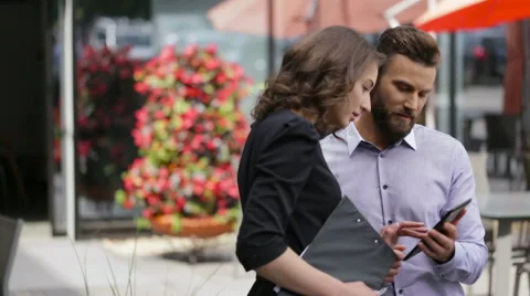 Two colleagues resting in the street in time of lunch Stock Footage 64114959