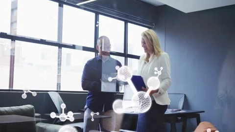 Two colleagues reviewing business docs, man tapping tablet causing molecules Stock Footage 333670489