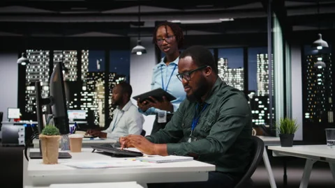 Two colleagues reviewing data insights and performance metrics for new reports Stock Footage 318499753