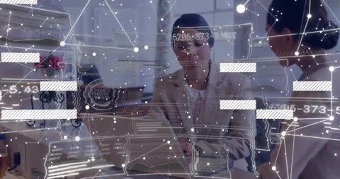 Two colleagues reviewing data at office desk, with floating analytics graphics, Stock Footage 327526169