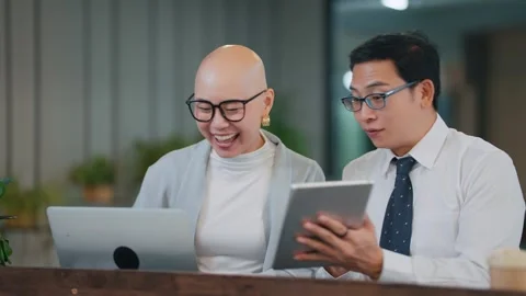 Two colleagues share a joyful moment over digital devices Stock Footage 346682035