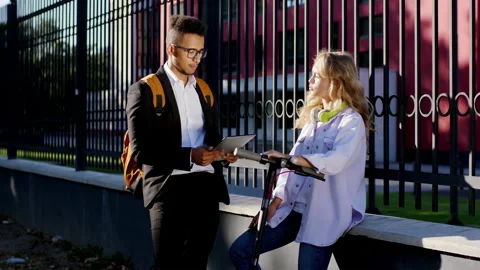 Two colleagues students Afro American guy and pretty lady with a electric Stock Footage 138160736