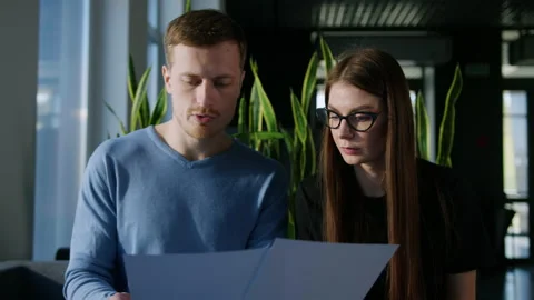 Two colleagues study the company's development schedules in the office Stock Footage 195204008