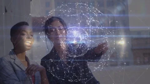 Two colleagues viewing hologram globe projecting near window, pointing nodes, Stock Footage 333833912