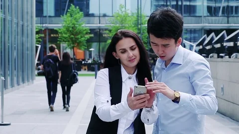 Two colleagues viewing project details on a smartphone Stock Footage 77466289