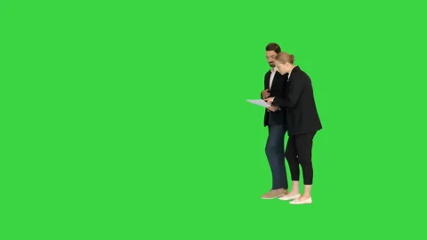 Two colleagues walking and looking at some documents on a Green Screen, Chroma Stock Footage 148338703