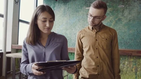 Two colleagues walking through the modern office and talking. Caucasian man and Stock-Footage 75592424