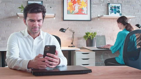 Two colleagues work and social distance while using their electronics, Stock Footage 137054645