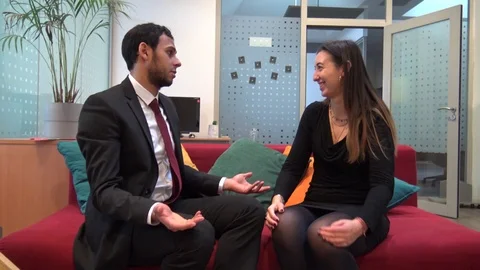Two colleagues at work laughing and chatting passionately in the office Stock Footage 126231813
