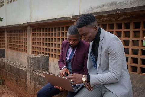 Two colleagues working an a project together look at a laptop screen, syner.. Stock Photos
