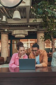 Two colleagues working on project together and use laptop sitting in coworking Stock Photos