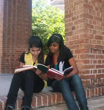 Two college friends exchanging notes. Foto stock