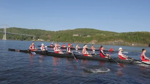 Two collegiate crew boats head towards a bridge Stock Footage 80656682