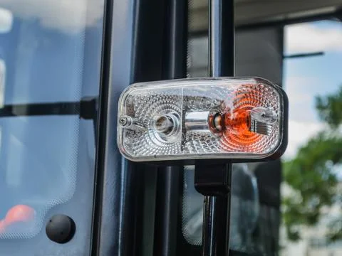 Two-color headlight on a side of the modern tractor cabin. Stock Photos