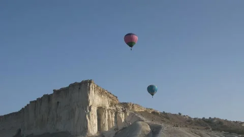 Two colored balloons in the sky against the background of white rocks at sunrise Stock-Footage 151139290
