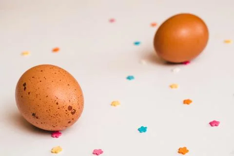 Two colored chicken eggs and pastry decorations on a light background Stock-Fotos