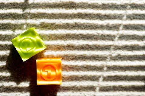 Two colored children's cubes lie on the floor Stock Photos