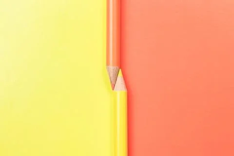 Two colored pencils on the border of different colors. Stock Photos