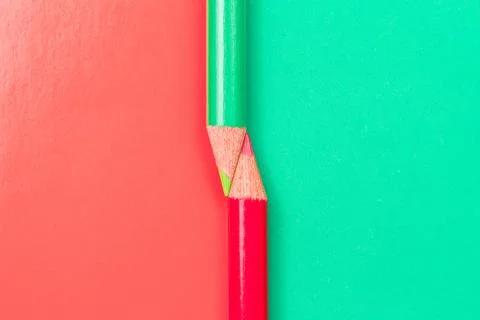 Two colored pencils on the border of different colors Stock Photos
