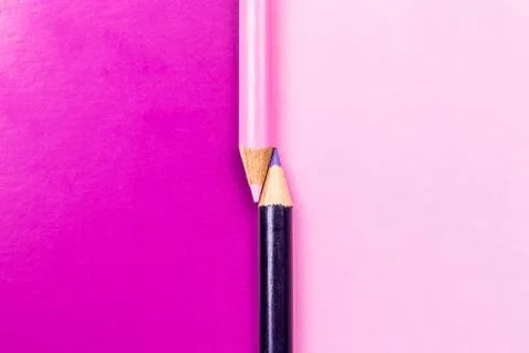 Two colored pencils on the border of different colors. Stock Photos