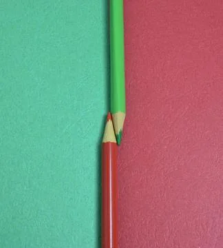 Two colored pencils split a picture in half in two different colors. copy pas Stock Photos