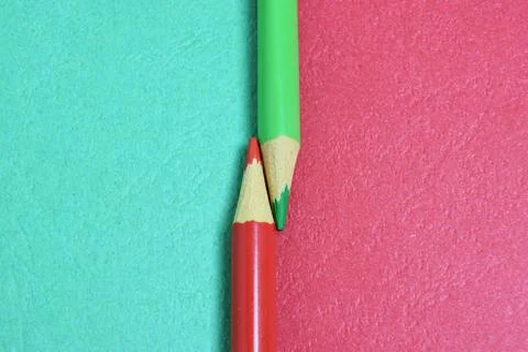 Two colored pencils split a picture in half in two different colors. copy pas Stock Photos