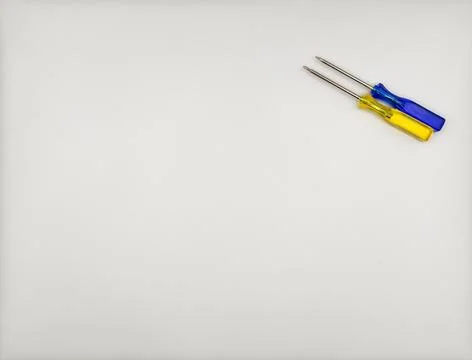 Two colored screwdrivers with plastic handles blue yellow top right on white Foto stock