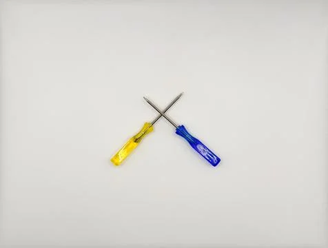 Two colored screwdrivers with plastic handles blue yellow in the center on a Stock Photos