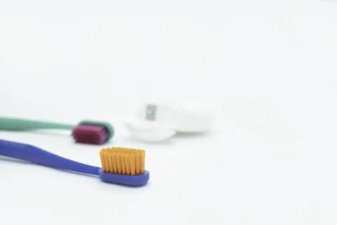Two colored toothbrushes with bright orange and red bristles and dental floss Foto stock