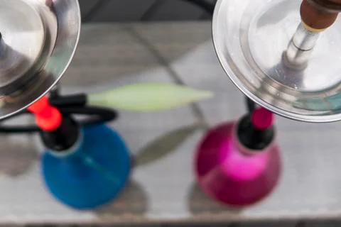 Two colors hookahs on table in hookah lounge in a day. Stock Photos