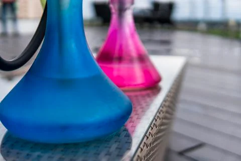 Two colors hookahs on table in hookah lounge in a day. Stock Photos