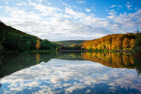 Two colours forest with perfect cloud reflection in the lake Stock Photos