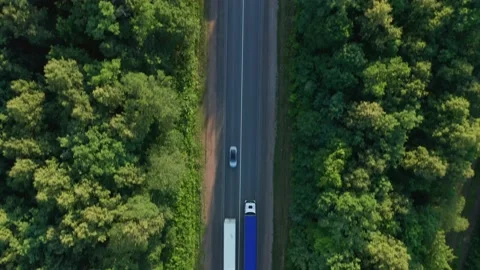 Two columns of trucks with long trailers move in different directions. The Stock Footage