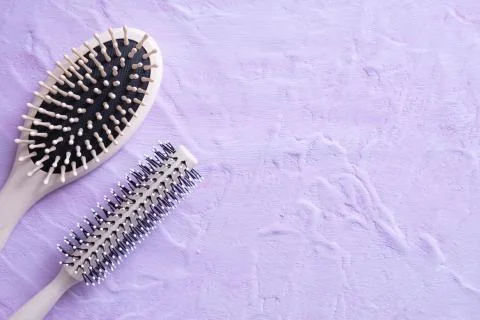 Two combs lie on a textured background Stock Photos