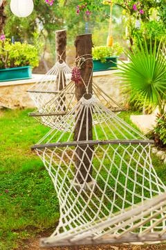 Two comfortable hammocks is gracefully hanging from a tree in a lovely garden Stock Photos
