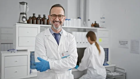 Two committed lab mates, a man and woman, standing relaxed with crossed arm.. Stock Footage 256404149