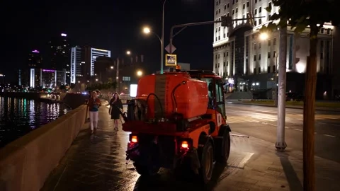 Two compact cleaning machines wash the sidewalk on the embankment  스톡 동영상 130480437
