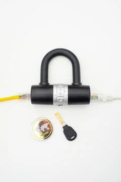 Two computer network cables going through a lock with a key and a crypto Stock-Fotos