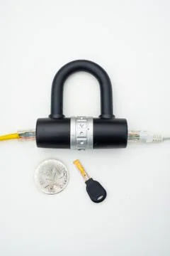 Two computer network cables going through a lock with a key and a crypto Stock-Fotos