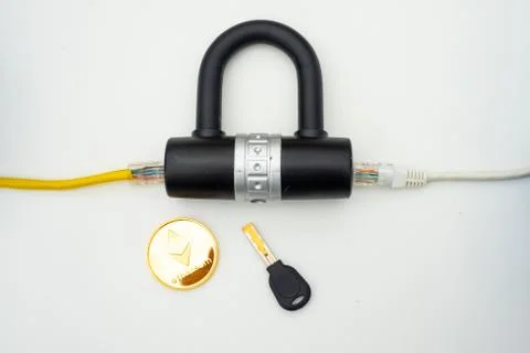 Two computer network cables going through a lock with a key and a crypto Fotos Stock
