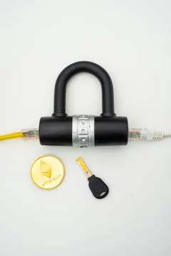 Two computer network cables going through a lock with a key and a crypto Fotos Stock