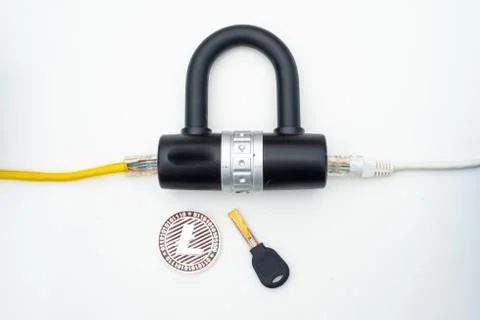 Two computer network cables going through a lock with a key and a crypto Fotos Stock