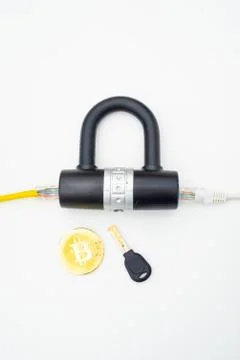 Two computer network cables going through a lock with a key and a crypto Stock Photos