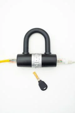 Two computer network cables going through a lock with a key Stock-Fotos