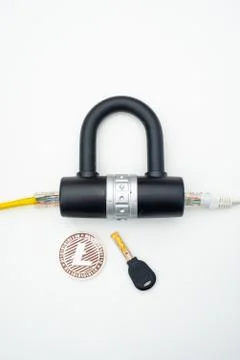 Two computer network cables going through a lock with a key and a crypto Fotos Stock
