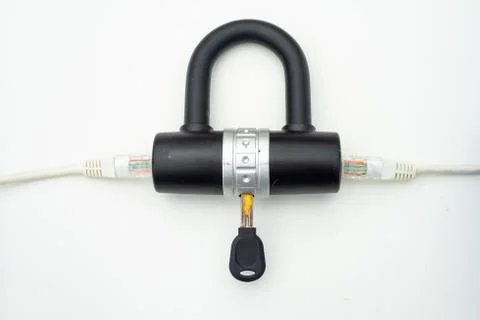 Two computer network cables going through a lock with a key Foto stock