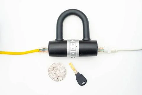 Two computer network cables going through a lock with a key and a crypto c... Foto stock