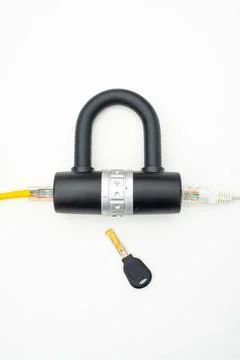 Two computer network cables going through a lock with a key Two computer n... Stock Photos