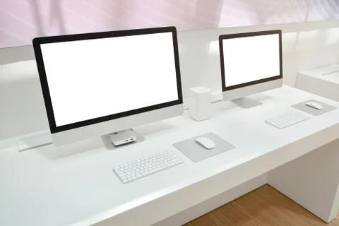 Two computers with isolated screens for mockup on office desk. Stock Photos